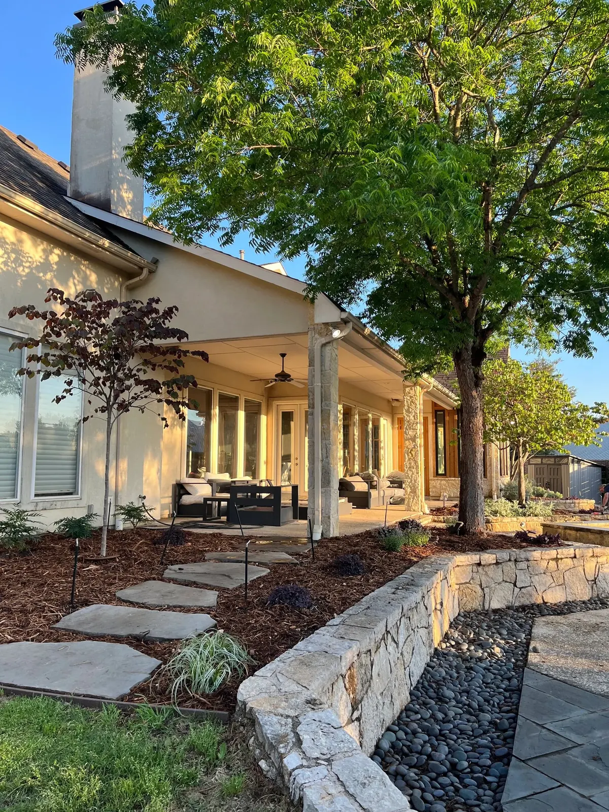 Front porch and beds lit at dusk after a full landscape install, Dallas TX
