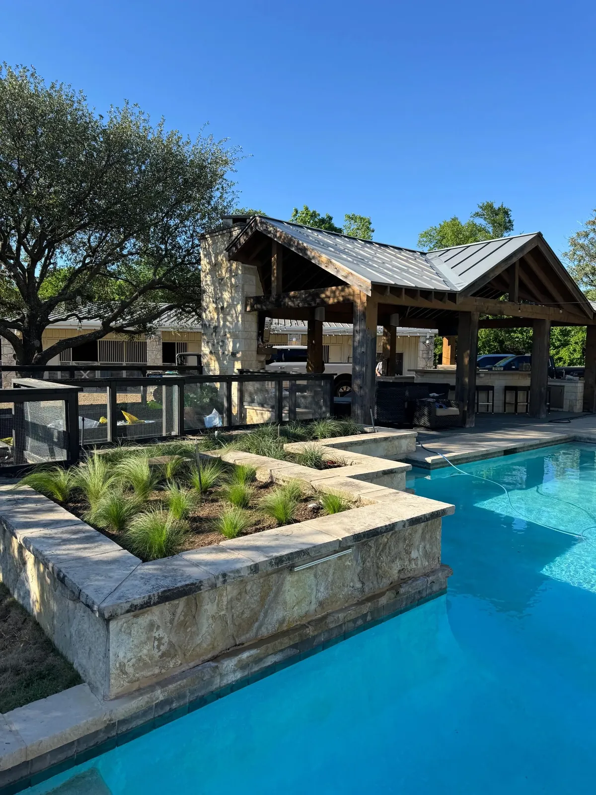 Finished backyard with pool, pergola, and fresh planting beds by Godoy's Wolves