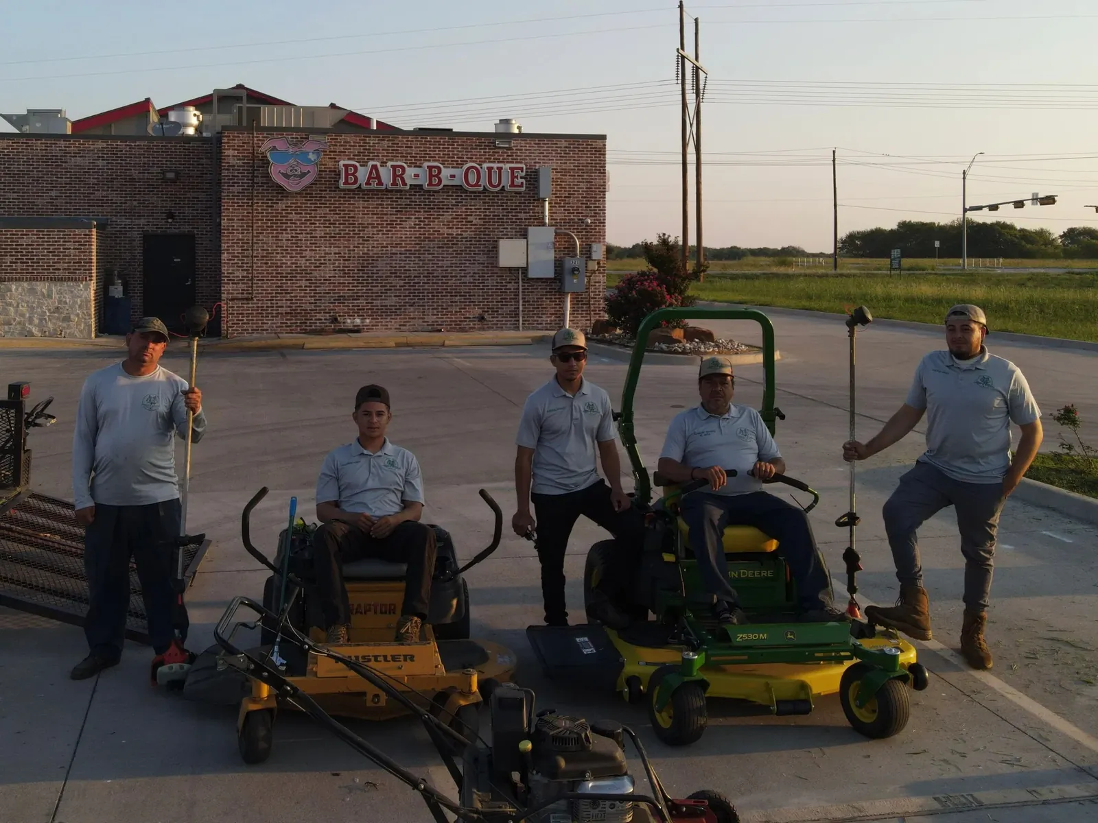 The Godoy's Wolves crew in uniform with their zero-turn mowers and trimmers before a route